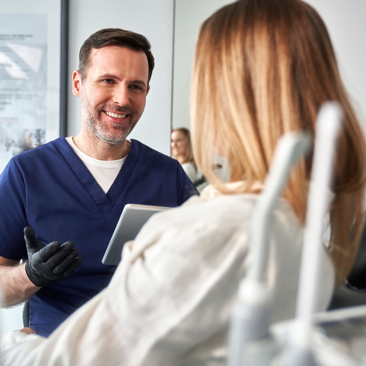 A dentist talking with his happy patient